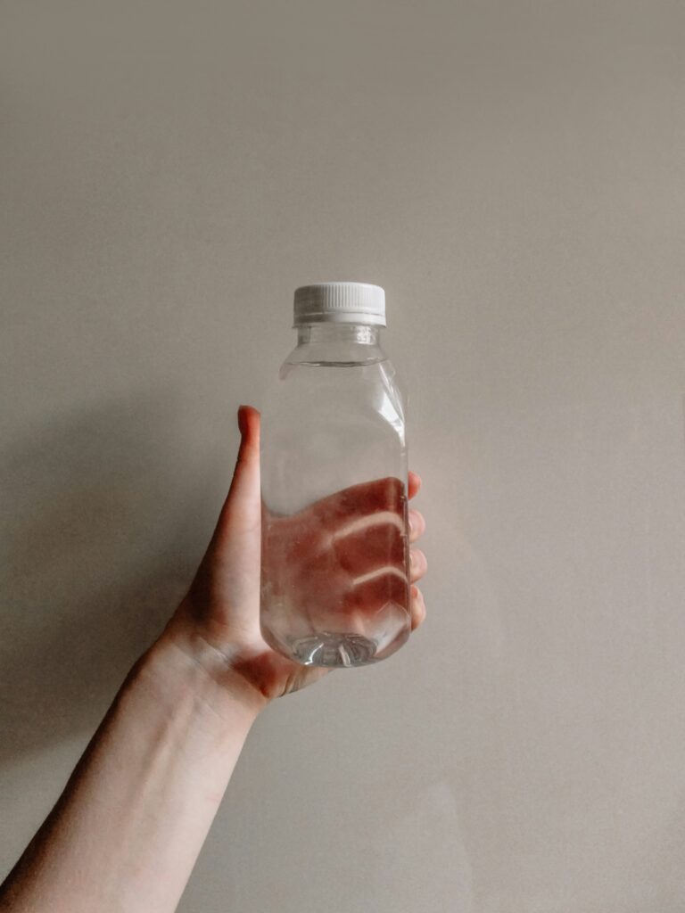 a person's hand holding a bottle of water