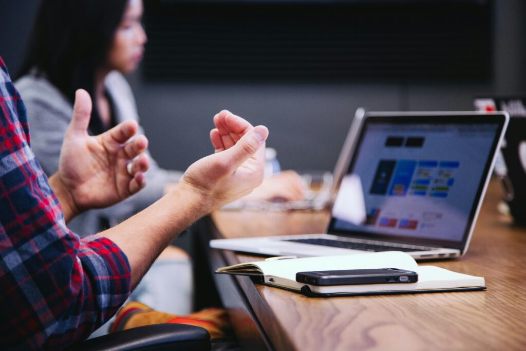 A man using hand gestures at the table during a meeting