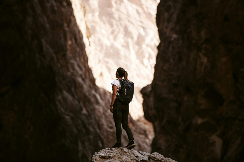 A young woman hiking through a valley looking up to possibility