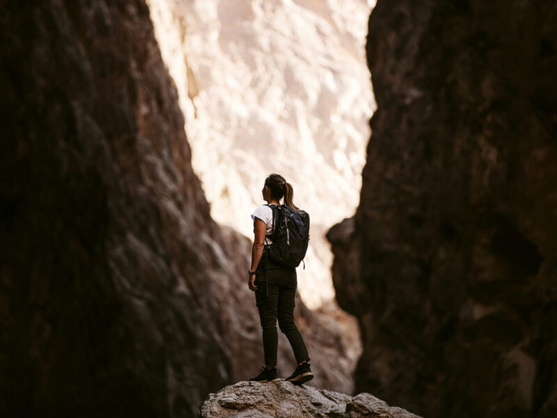 A young woman hiking through a valley looking up to possibility