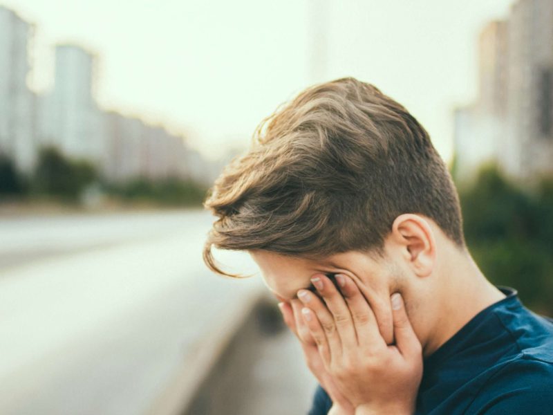 a man looking exhausted with his head down in his hands