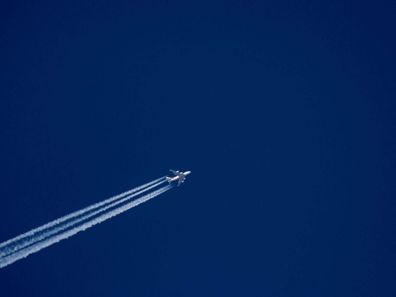 jet plane and trail across a dark blue sky