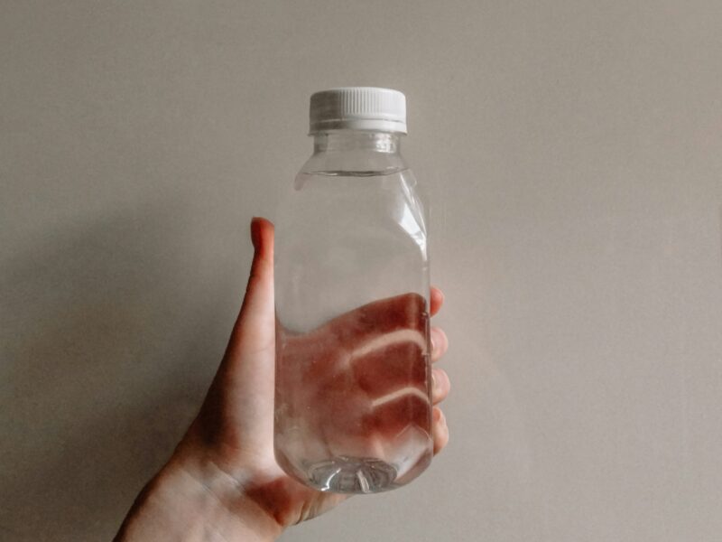 a person's hand holding a bottle of water
