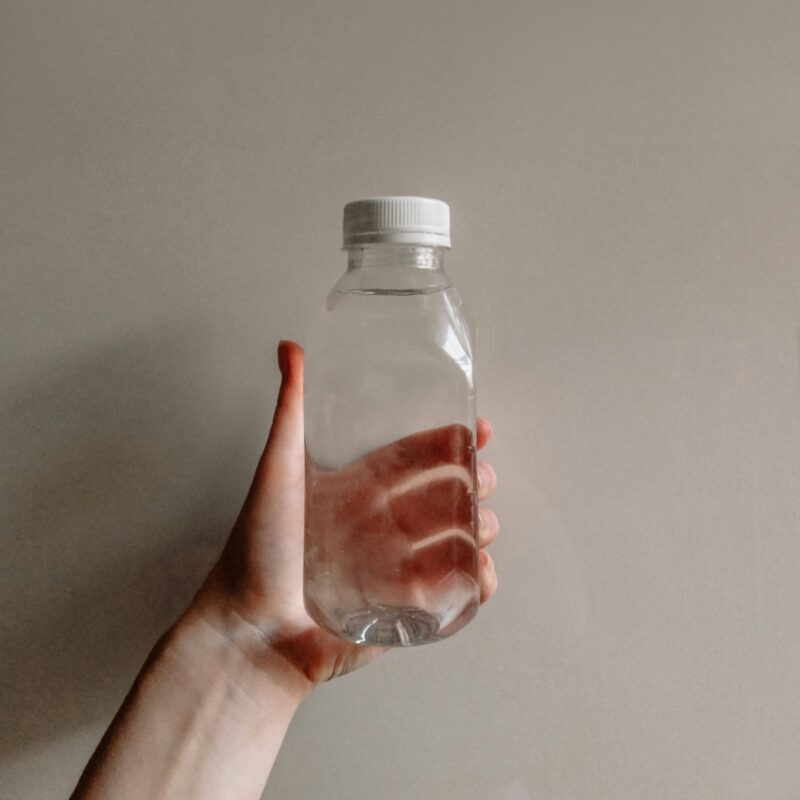a person's hand holding a bottle of water